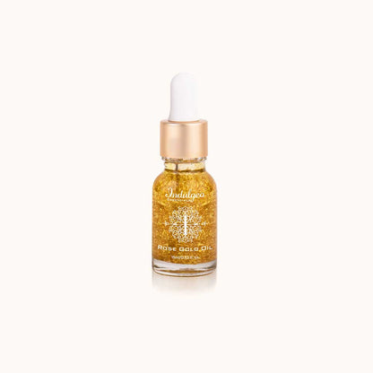 Clear glass dropper bottle of Indulgeo Essentials Rose Gold Oil with visible 24k gold flakes and rose gold cap, 15ml size